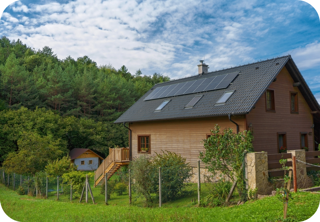 Solar panels on house with wood siding and small trees in the yard