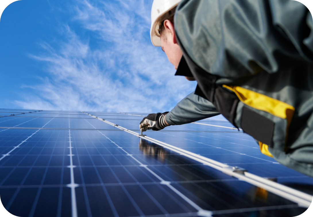 Maintenance worker reaching up to work on a solar panel