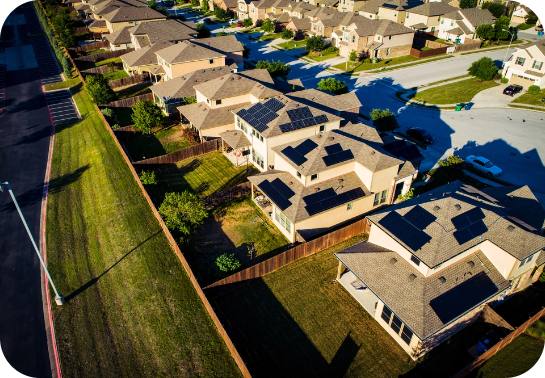 A birdseye view of multiple homes with solar panels
