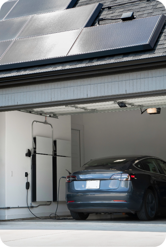 A car charging inside the garage with solar panels mounted on top of garage roof