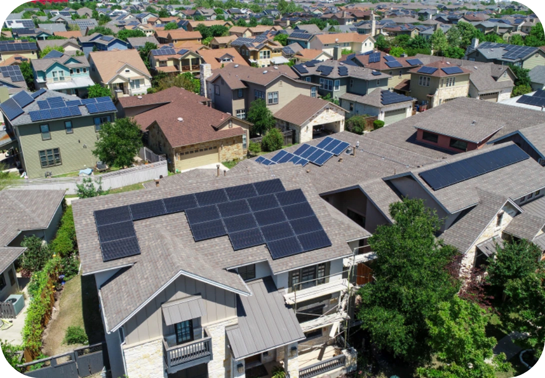 Solar panels on many roofs in a neighborhood with an aerial view