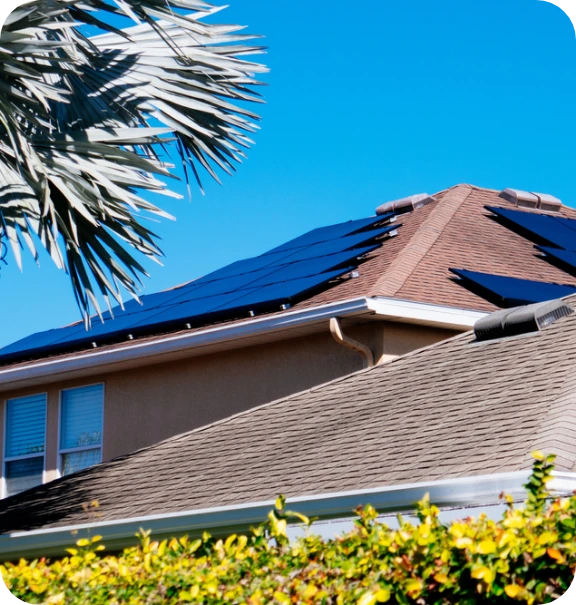 Solar panels on a roof with palm trees around